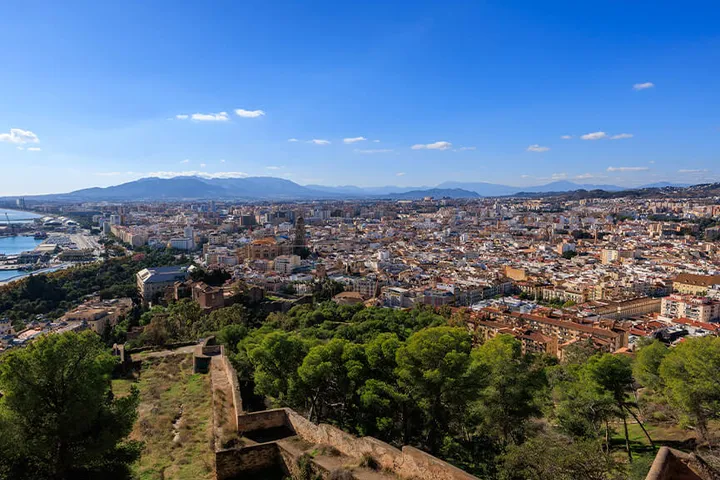 Málaga’s rooftops and cathedral with mountains beyond, viewed from above